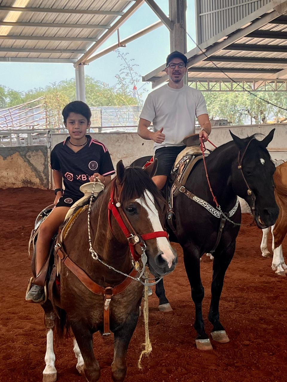 Papá e hijo montando a caballo